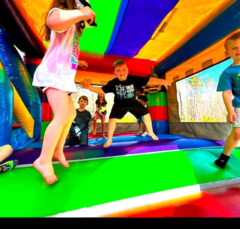 Kids jumping and laughing inside a bounce house rental — Party Go Round Cincinnati