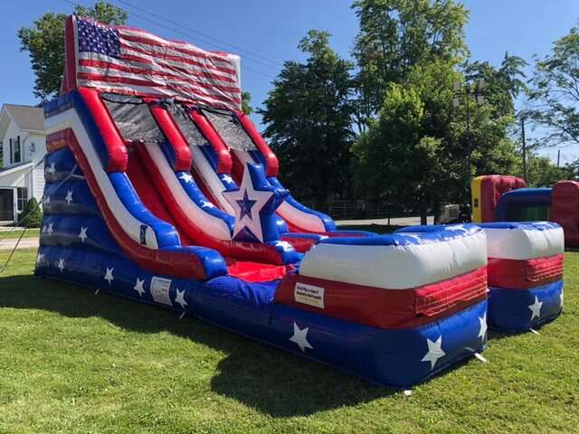 Patriotic American flag-themed water slide rental, offered by Party Go Round, making a statement at a Maineville, OH event, with vibrant red, white, and blue colors and star patterns, perfect for Fourth of July celebrations or any festive gathering.