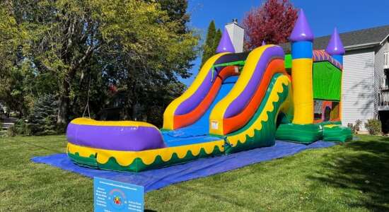 Backyard party with a combo bounce house and slide rental from Roundhouse Inflatables