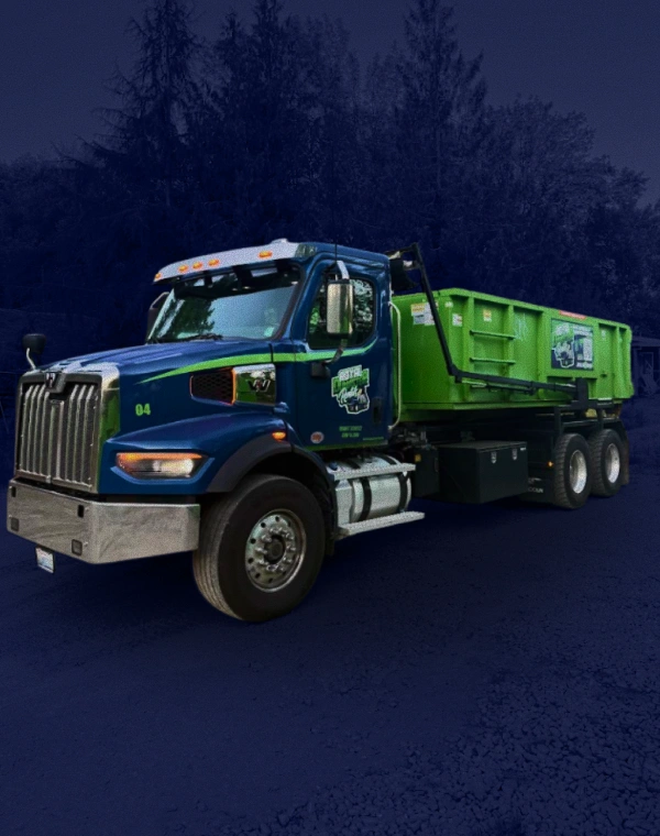 Dumpster rental truck delivering a green roll-off container in Puyallup, WA