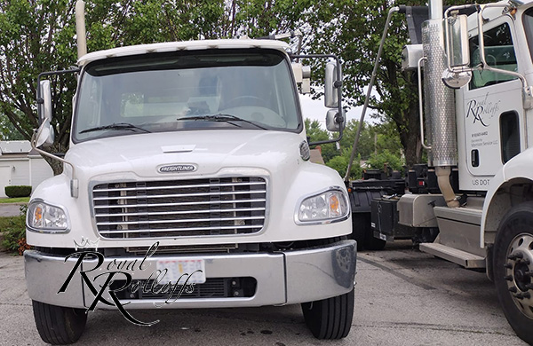 Royal Rolloffs white Freightliner truck parked beside another company vehicle. Royal Rolloffs white Freightliner truck parked beside another company vehicle.