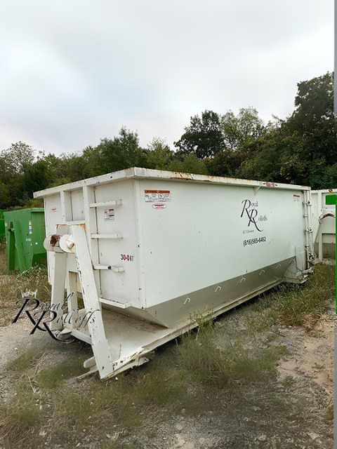 Royal Rolloffs white dumpster container placed on a gravel and grass lot. Royal Rolloffs white dumpster container placed on a gravel and grass lot.