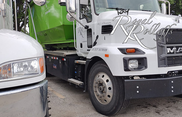 Gleaming Royal Rolloffs truck in white with the company’s logo, ready to transport a dumpster in Lenexa, Kansas