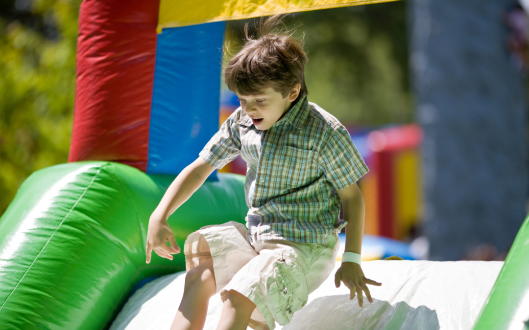 Boy playing on backyard bounce house
