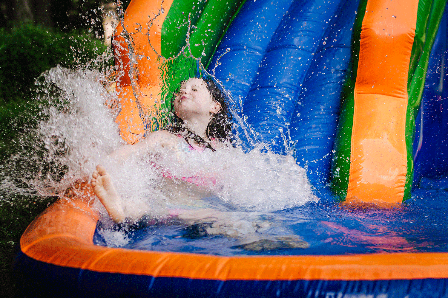 Child splashing on inflatable water slide
