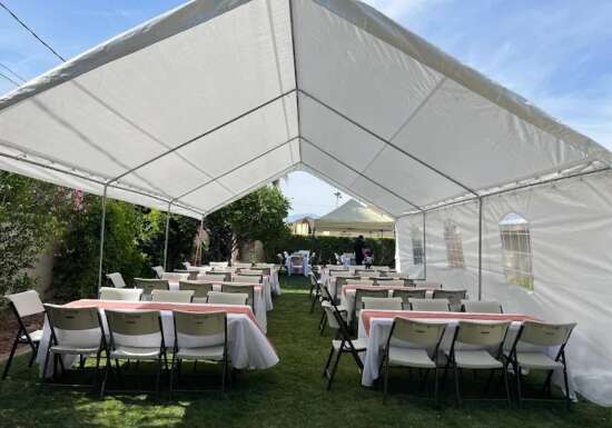 White party tent with tables and chairs set up by Shaylas Party Rental
