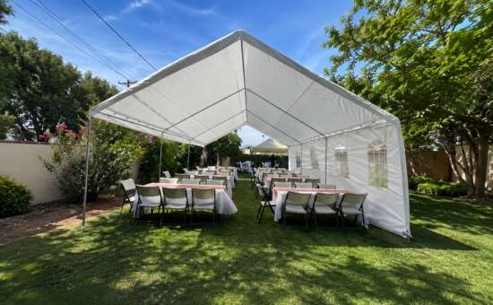 White party tent with tables and chairs set up by Shaylas Party Rental