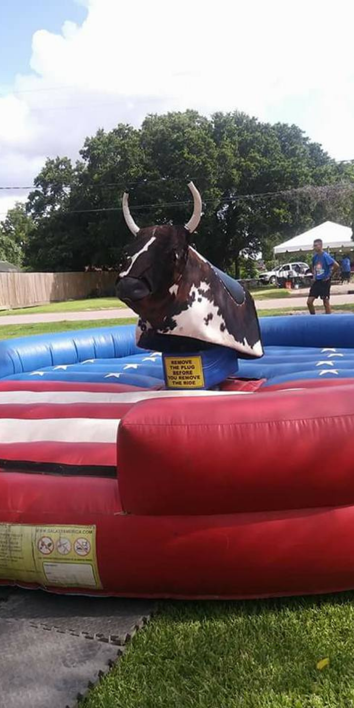 Showcase Entertainment mechanical bull with American flag patterned inflatable base.