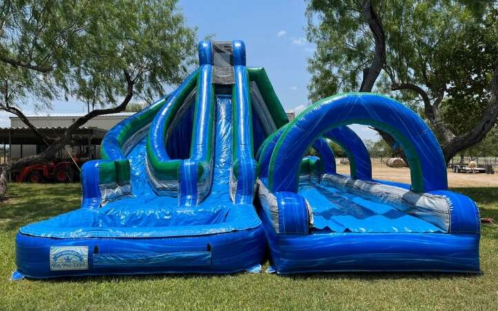 Child going down a water slide rental on a hot day in McAllen, TX
