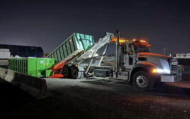Roll-off truck with green dumpsters at a commercial site providing business waste service by Sparks Enterprises LLC Roll-off truck with green dumpsters at a commercial site providing business waste service by Sparks Enterprises LLC