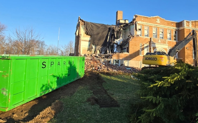 Green dumpster at a site for construction waste by Sparks Enterprises LLC Green dumpster at a site for construction waste by Sparks Enterprises LLC
