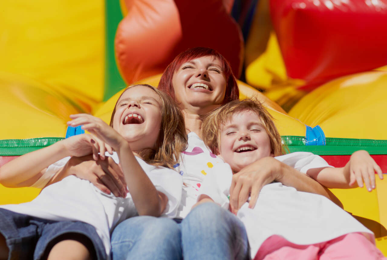 Happy children jumping and playing on colorful bounce house at Adel Georgia birthday party celebration
