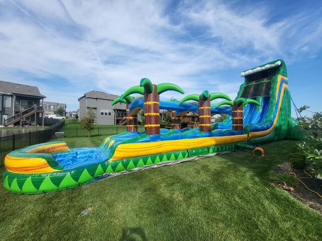 27 foot dual lane tropical water slide rental set up in a Lee's Summit backyard