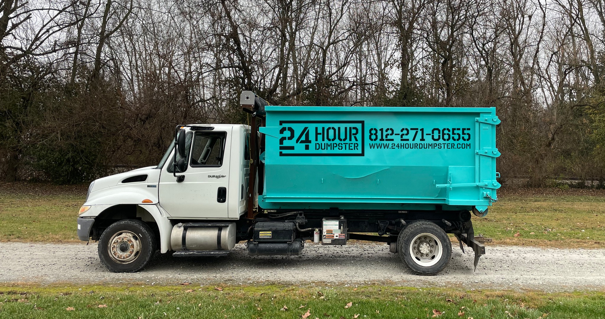 24 Hour Dumpster truck delivering a roll-off dumpster to a residential property