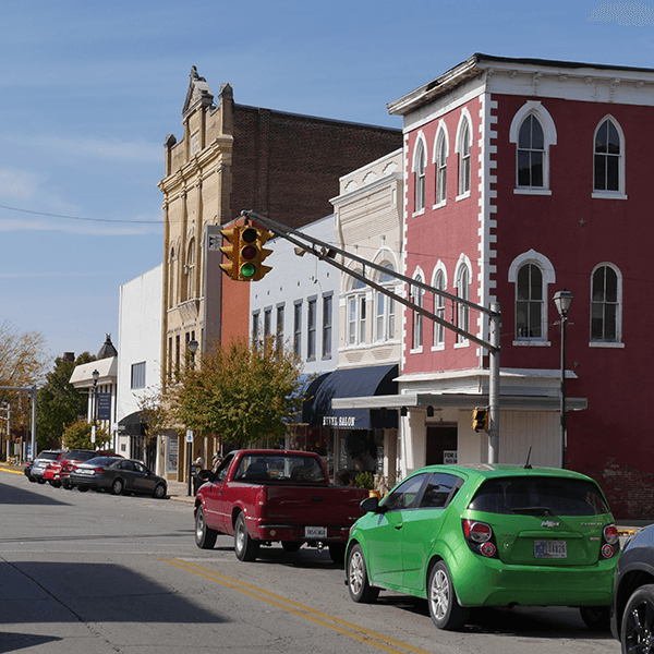 Small-town main street with colorful historic buildings and parked cars