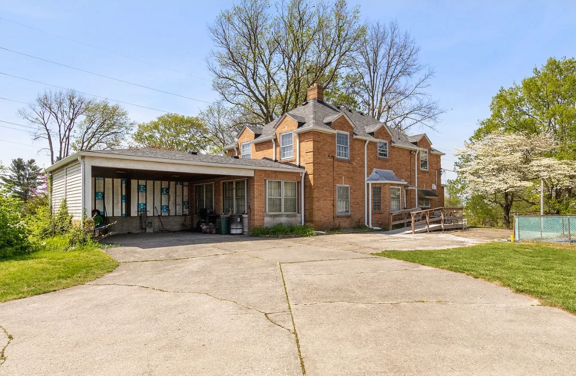 Two-story brick home with attached carport and ramp access