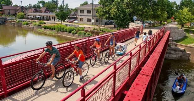 Family riding bicycles across a bridge in Broad Ripple, Indianapolis.