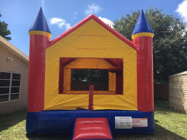 bounce house with slide and basketball hoop