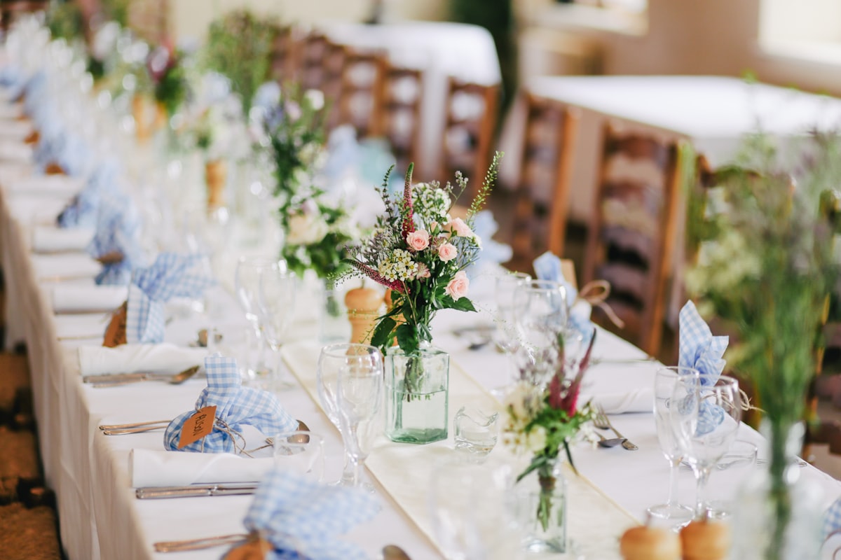 garden party long table with linens and blue accents set near Grand Rapids