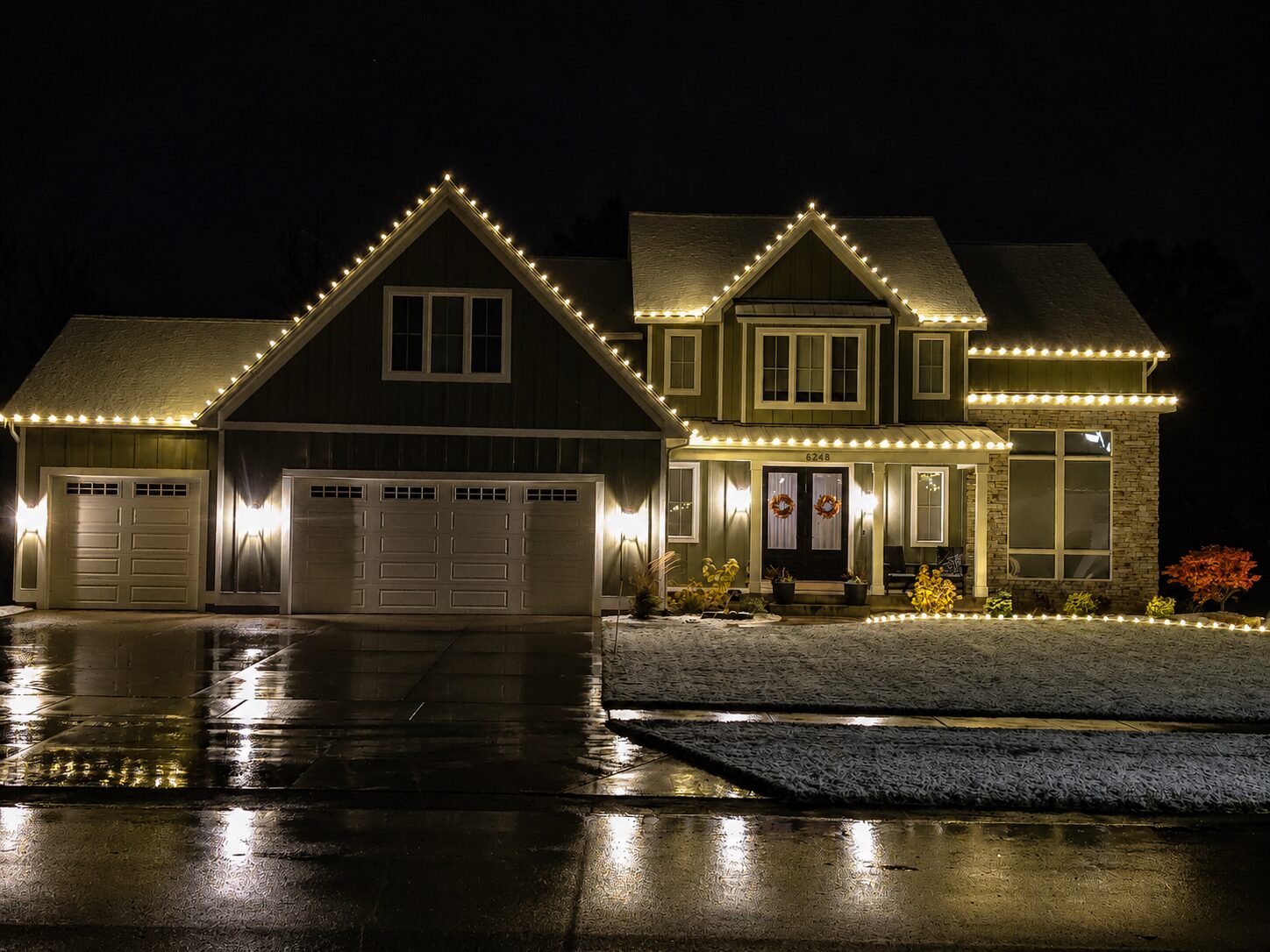 Warm white Christmas light installation on a Grand Rapids two story home