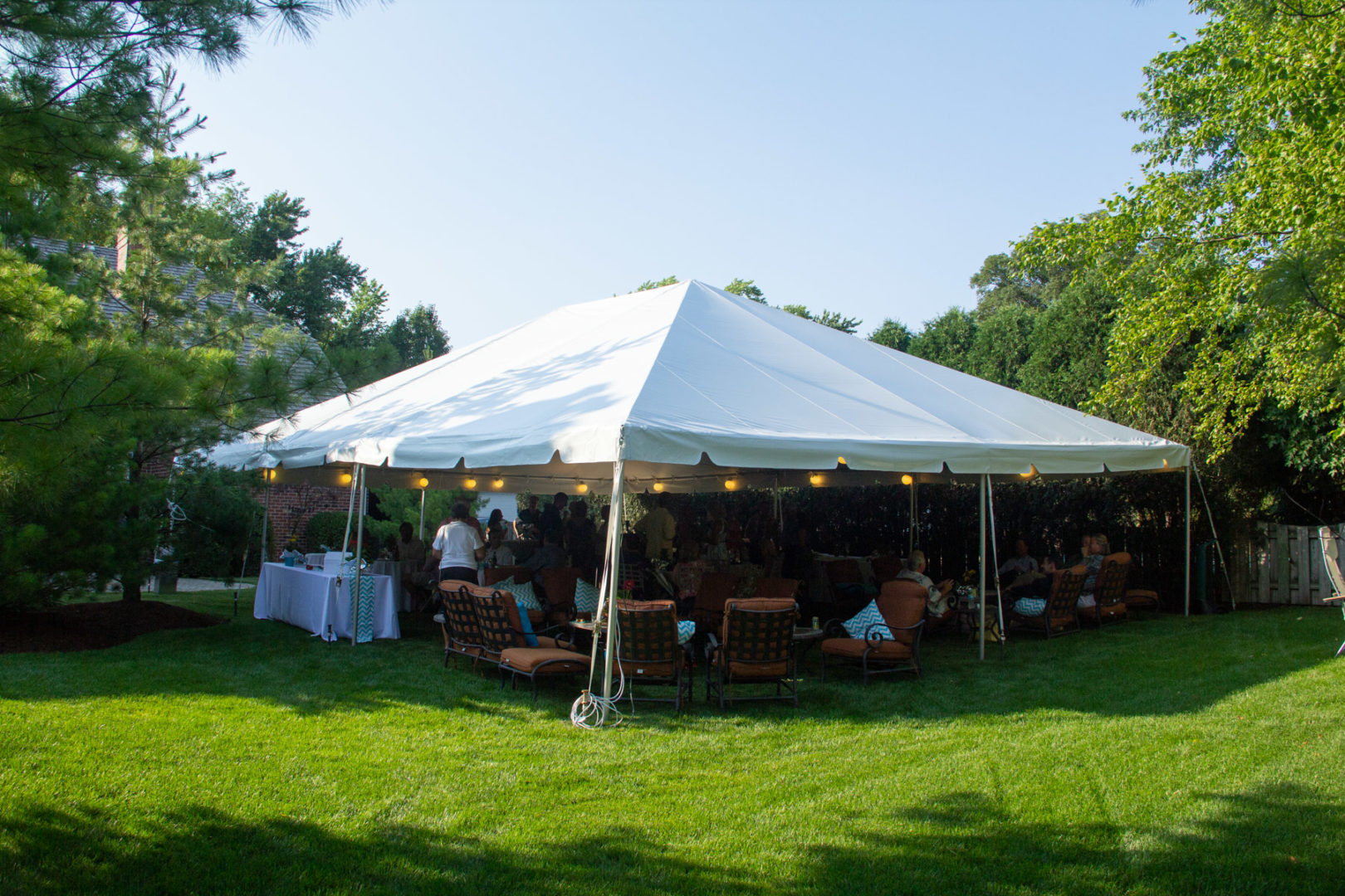 Party tent filled with guests enjoying an outdoor celebration Party tent filled with guests enjoying an outdoor celebration
