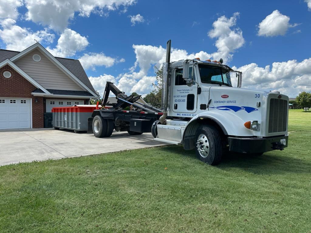 Dumpster truck parked outside a residential home Dumpster truck parked outside a residential home