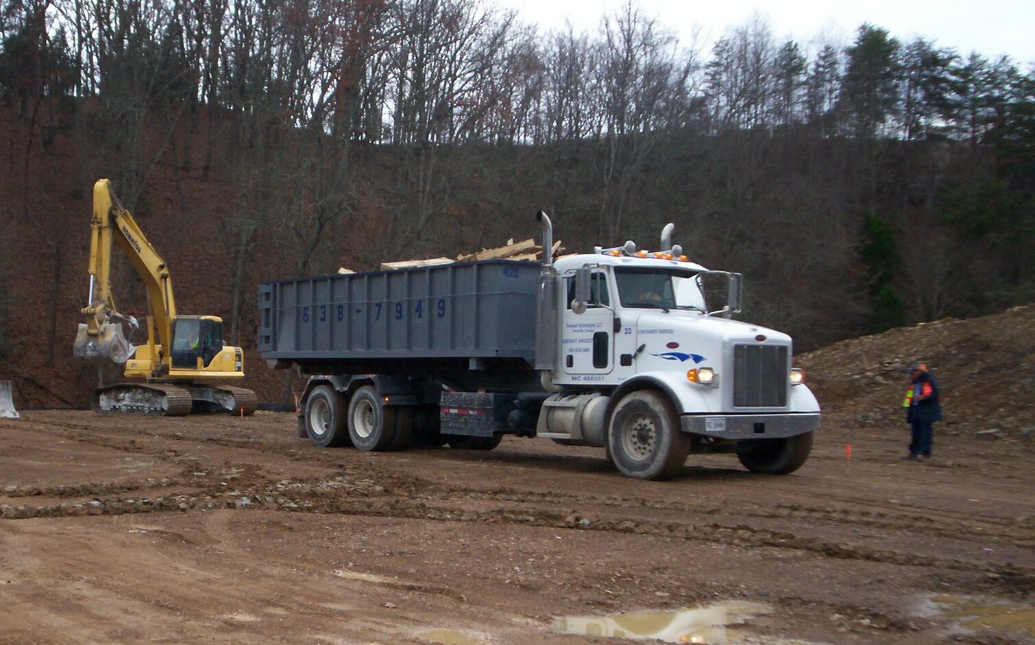 Transport Technologies dumpster truck working on a job site Transport Technologies dumpster truck working on a job site