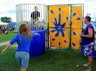 Adult throwing a ball at the dunk tank