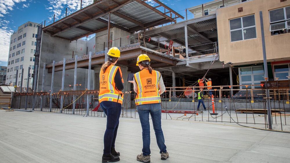 Two people coordinating tasks on an active jobsite