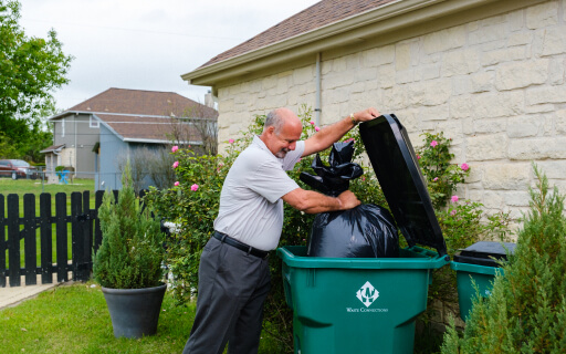 Person taking out household trash to the curb