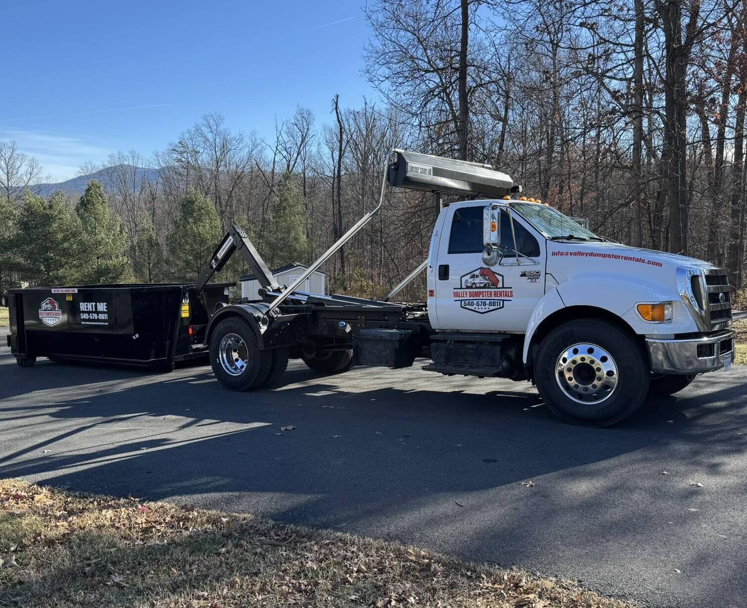 Valley Dumpster Rentals truck delivering a roll-off dumpster in the Shenandoah Valley