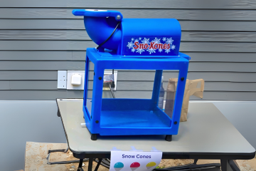 Blue snow cone machine on a table, offered by Vertical Entertainment.