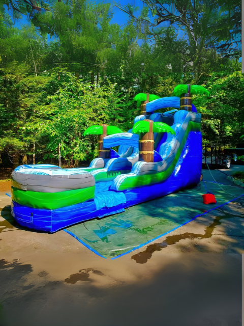 Vertical Entertainment inflatable tropical water slide with palm tree decorations.