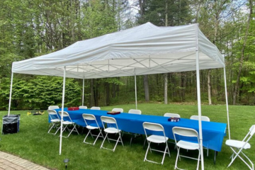 Outdoor white party tent with tables and chairs by Vertical Entertainment