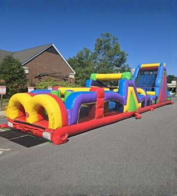 Colorful inflatable obstacle course rental setup outdoors by Vertical Entertainment