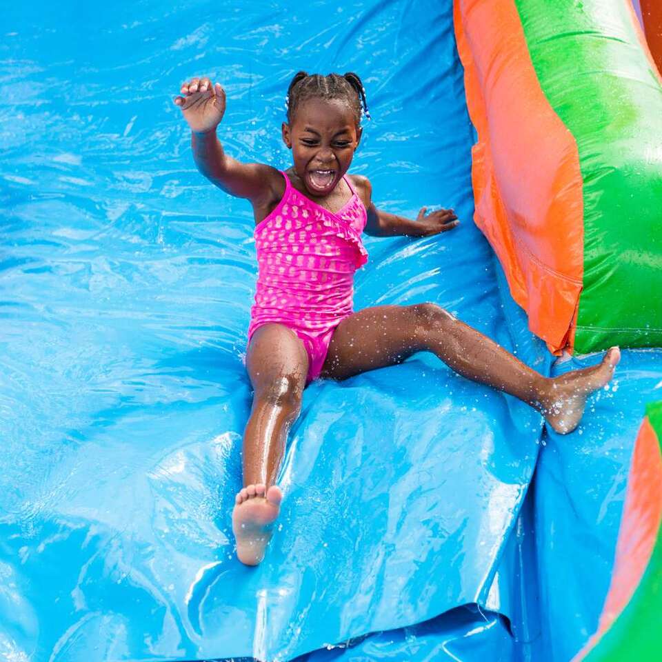 Water Slides to rent in Taylor, Tx from We Bring the Party showing a little girl sliding down a water slide Water Slides to rent in Taylor, Tx from We Bring the Party showing a little girl sliding down a water slide