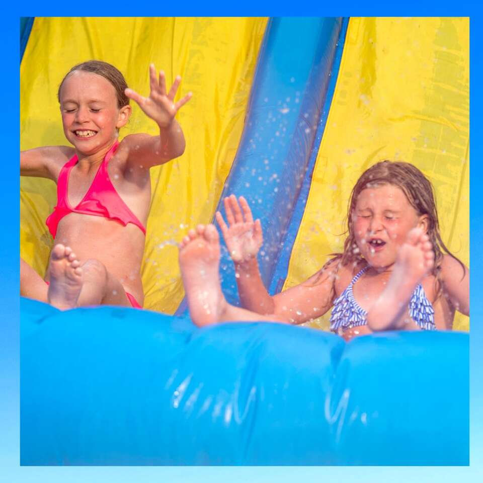 Water Slide Rentals in Manor. Tx from We Bring The Party showing two girls sliding down a water slide Water Slide Rentals in Manor. Tx from We Bring The Party showing two girls sliding down a water slide