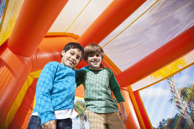 Two little kids smiling in an inflatable caslte Two little kids smiling in an inflatable caslte